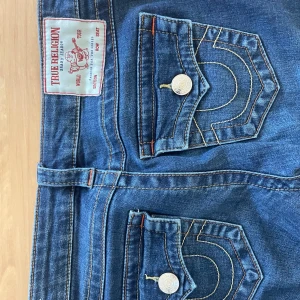 Mörkblåa true religion jeans - strl 24, jag har sytt upp ca 4 cm på benen i butik så inget som syns. Mycket bra skick 