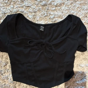 Svart ribbad topp - Snygg svart ribbad topp. Den har blivit använd 1-2 gånger