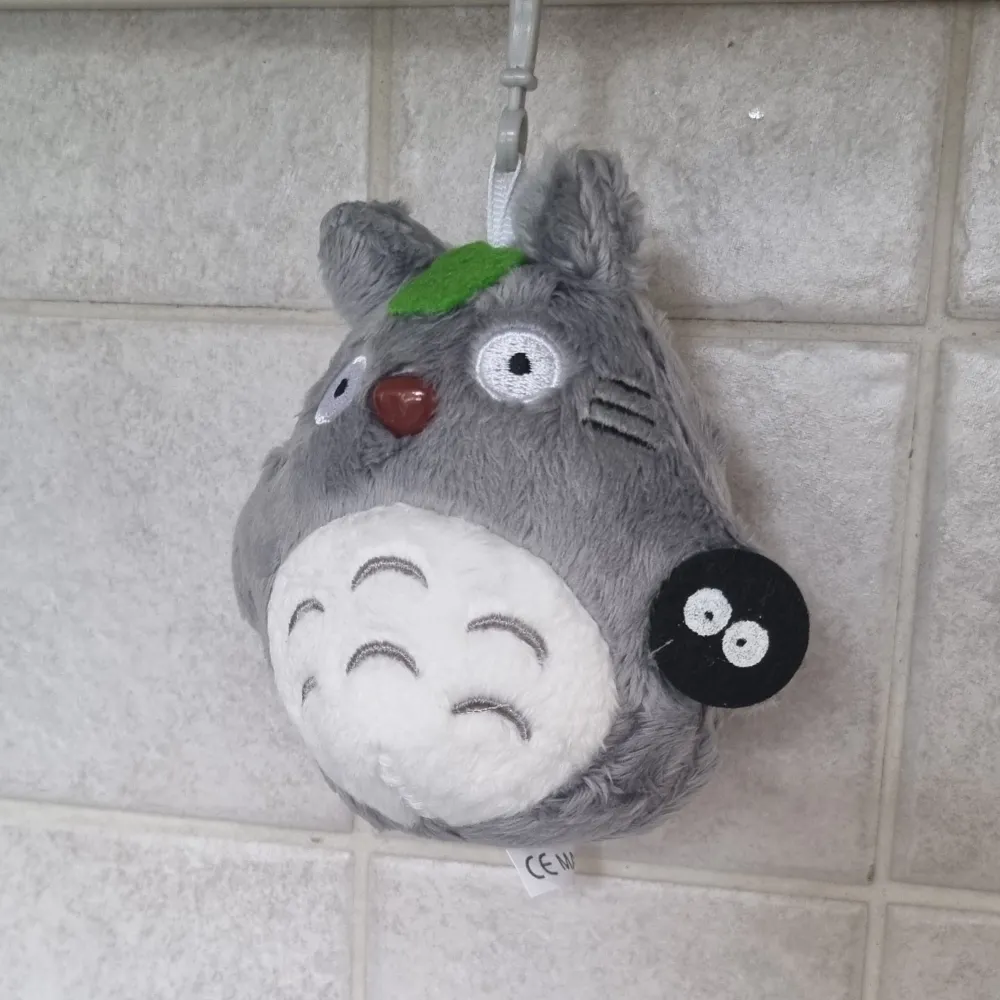 Söt grå Totoro nyckelring med broderade detaljer och en liten svart figur. Perfekt som accessoar för att ge en personlig touch till dina nycklar eller väska.. Asusteet.