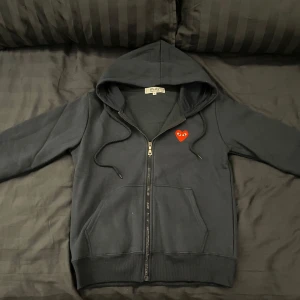 Comme des Garçons Zip-hoodie - Säljer denna full-zip hoodien från Cdg. | Skicka är så gott som nytt. | Den är i en mörkblå/marinblå färg men en röd logga. | Det är bara att höra av sig om man har några frågor eller funderingar kring hoodien⭐️⭐️⭐️