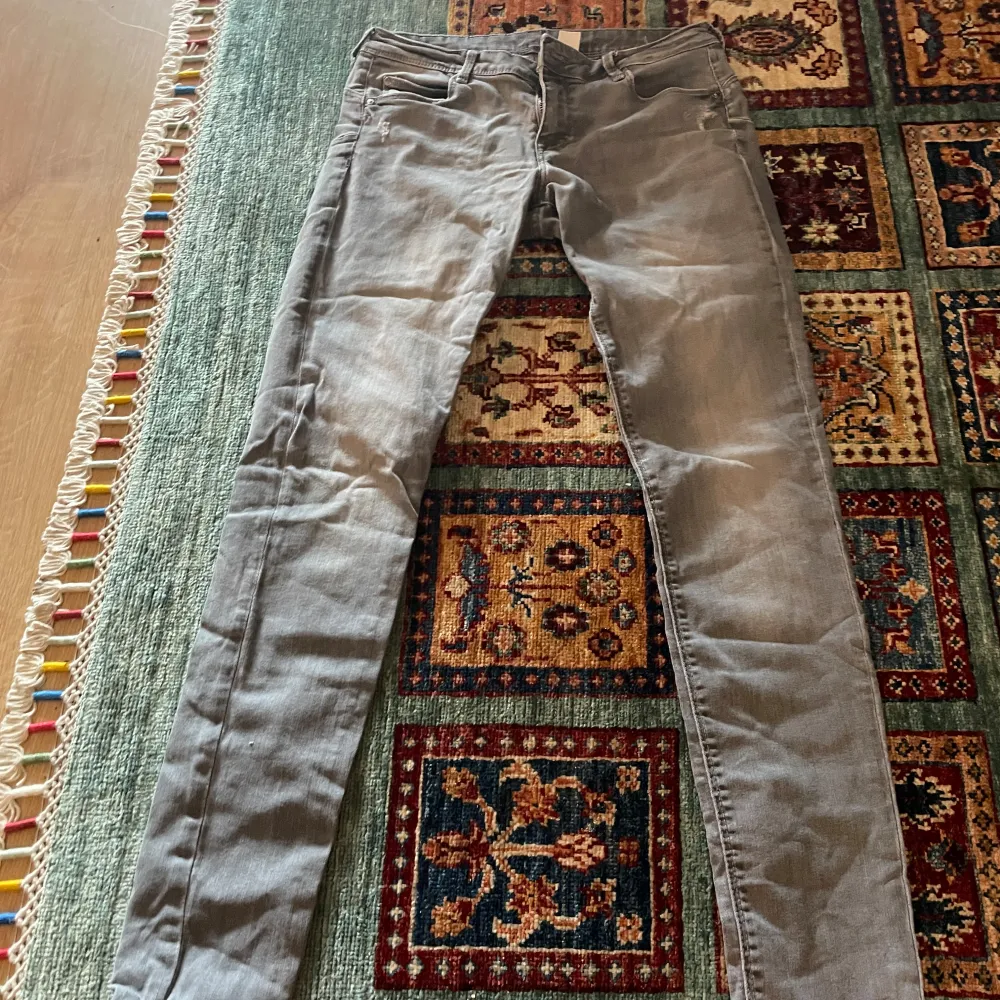 Snygga grå jeansbyxor med en klassisk femficksdesign. Byxorna har en smal passform och är perfekta för en stilren look. De är tillverkade i ett bekvämt material som ger en bra rörelsefrihet.. Farkut & Housut.