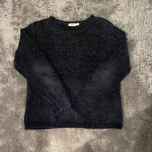 Svart ribbad tröja  - Säljer en svart/mörkblå stickad tröja. Den är från Kappahl och har ett otroligt mjukt material. Storlek 158-164