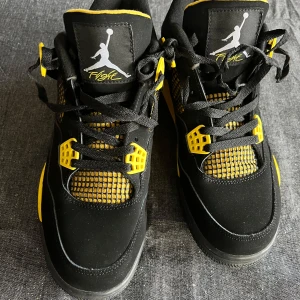 Nike air jordan 4 - Snygga Nike Air Jordans i svart och gult med ikonisk Jumpman-logga. Skorna har snörning och en cool design med meshdetaljer. Perfekta för att sticka ut med stil. Skorna är storlek 44 och är helt nya. Endast använda 1 gång! 