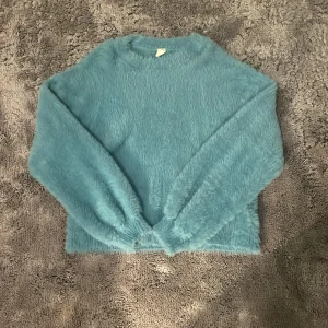 Blå fluffig tröja - Mysig blå tröja med fluffigt material och långa ärmar. Nästan aldrig använd, storlek 146-152