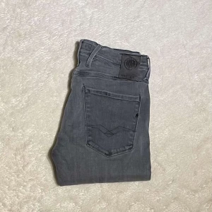 Grå Replay anbass - Snygga grå replay anbass jeansbyxor i storlek 28. Jeansen har normal passform och är i mycket bra skick.
