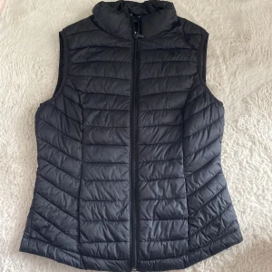 Svart väst - Säljer en svart dunväst från Primark. Västen är superlätt och packbar med dragkedja framtill. Perfekt för lager-på-lager under kyliga dagar.