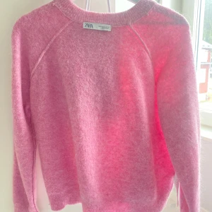 Rosa stickad tröja från Zara - Säljer en mysig rosa stickad tröja från Zara. Tröjan har en enkel design med långa ärmar och rund halsringning. Perfekt för kyliga dagar.