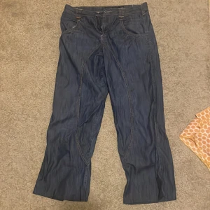 Mörkblå byxor med fickor - Säljer ett par mörkblå byxor med tunnare jeans material. Midja tvärs över är 39cm och inerbenslängd är 66 cm.