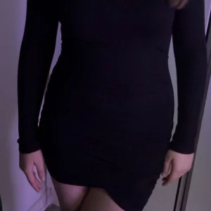 Svart kortklänning - Snygg svart tight klänning med långärmad design. Perfekt för en stilren och elegant look. Klänningen är kort och framhäver figuren på ett smickrande sätt.