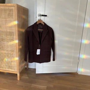 Ny stickad kavaj John Henric  - Ny stickad kavaj från John Henric. Storlek XS. Färg brun. Nypris 1499 kr.  Två knappar framtill. Storsäljare, slutsåld på John Henric 