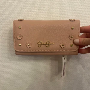 Jessica Simpson - Jessica Simpson plånbok. Rymlig och fin! Aldrig använt har fortfarande kvar prislapp. Lite smutsig då den har legat undanplockad men det går att få bort.