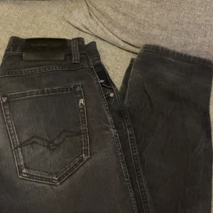 Svartgrå Replay jeans - Snygga svarta jeans från Replay med klassisk femficksdesign och en stilren look. De har en normal passform och är perfekta för en avslappnad stil. Storlek W29 L32 och jeansen är i mycket bra skick! För mer frågor är det bara och höra av sig! 