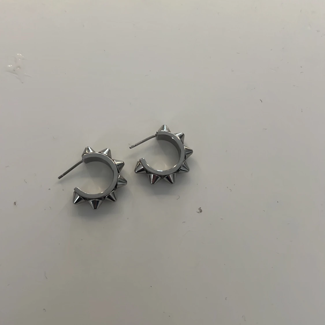 Silvriga örhängen med nitar