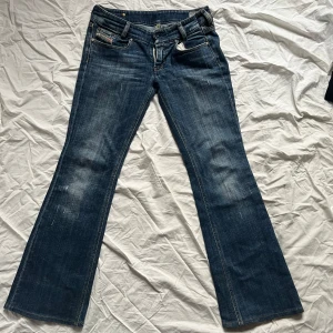 Blå jeansbyxor från Diesel - Snygga blå jeansbyxor från Diesel med bootcut-stil. dragkedjan är sönder, men har sytt ditt en knapp som funkar lika bra! 
