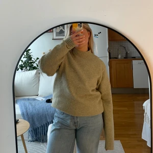 Grön tröja från Uniqlo - Säljer en grön tröja från Uniqlo i storlek S. Tröjan är tillverkad av en blandning av akryl, polyester och ull, vilket gör den både mjuk och varm. Den har långa ärmar och en klassisk rund halsringning. Perfekt för kyligare dagar!