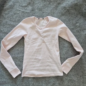 Rosa ribbad topp med knappar  - Sparsamt använd. Fint skick. Ser ingen storlek men uppskattar att den passar XS-S.
