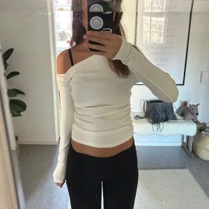 Vit offshoulder topp - Säljer en stilren vit offshoulder topp med lång ärm. Perfekt för en trendig look. Passar bra till både jeans och kjol.