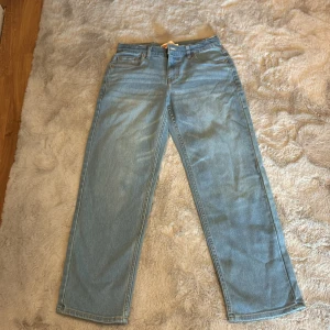 Levi's Loose Taper jeans - Säljer ett par ljusblå Levi's Loose Taper jeans. De har en avslappnad passform med avsmalnande ben och klassiska femficksdetaljer. Perfekta för en casual look.