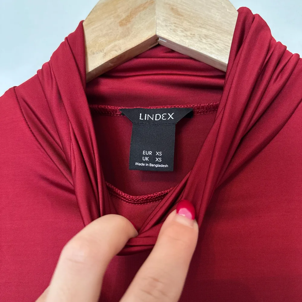 Snygg röd polotröja från Lindex i satin. Perfekt för kyligare dagar med sin långa ärmar och klassiska polokrage. En stilren baströja som passar till mycket.. Neuletakit & Villapaidat.