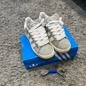 Adidas Campus, gråa - Helt nya och oanvända Gråa adidas campus skor, 10/10 skick. Det är inga skador eller defekter. Dem säljs pga jag inte gilla dom så mycket. Det är storlek 43 och sitter som 43. Rekommenderar starkt! Hör av er vid frågor!