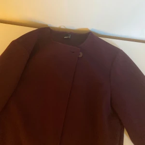 Vinröd jacka från Gina  - Nypris 500 kr, använd två gånger endast! Om man inte gillar knappen är det bara att vika över så syns den inte😌Lagom tjock till våren och början av hösten