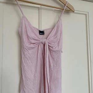 Ljusrosa linne - Jättefin ljusrosa design by si liknande topp med knytning framtill. Aldrig använd, med prislappen kvar!