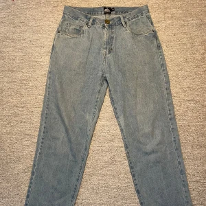 Blå jeans från Southpole - Säljer ett par klassiska blå jeans från Southpole. De har en normal passform och är tillverkade i jeansmaterial. Baktill finns en snygg broderad detalj med Southpole-loggan på fickan. Perfekta för en avslappnad stil.