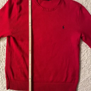 Röd tröja från Polo Ralph Lauren - Säljer en snygg röd tröja från Polo Ralph Lauren i storlek L (etiketten säger M men skulle säga det är L). Tröjan är i mycket bra skick.