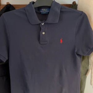 Mörkblå pikétröja från Ralph Lauren - En snygg Ralph lauren pike som är nyskick och som Aldrig har andvändts. Sitter som s i storlek. 