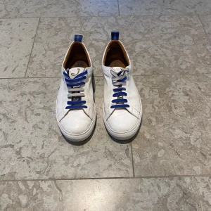 Jacob Cohen sneakers  - Snygga vita sneakers från Jacob Cohen med blå snörning och rund tå. Perfekta för en stilren look. Skorna har en klassisk design med en bekväm passform. Stolek 40,5 men lite stora i stolek. Skorna är i relativt bra skick dom är använda men har fortfarande mycket kvar att ge skick 8/10. Box följer med. Skriv privat för fler bilder och vid minsta fundering.