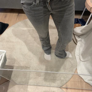 Grå jeans (Gina) - Grå jeans med detaljer på bakfickorna.