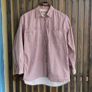 Rutig skjorta från Vero Moda - Rutig skjorta från Vero Moda i vitt och rött. Klassisk krage, två bröstfickor och knäppning framtill. Långärmad modell i mjuk bomull, perfekt för en avslappnad och cool look. Storlek S men passar även M beroende på vilken passform man söker. 