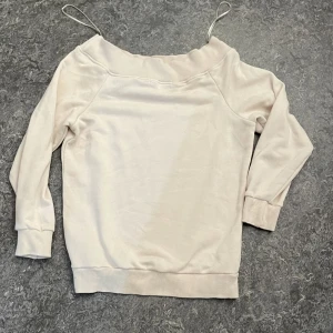 Offshoulder beige tröja från BikBok - Snygg offshoulder tröja från BikBok i en ljus beige färg. Tröjan har långa ärmar, bred mudd vid halsringningen och är tillverkad i mjuk bomullsmix. Perfekt för dig som gillar en chill och trendig stil.
