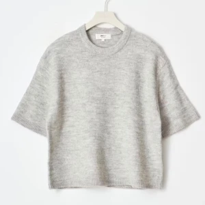 Grå stickad kortärmad tröja Arket - Supermjuk grå stickad tröja från Gina tricot med korta ärmar och rund hals. Perfekt för lager-på-lager och chill stil. Tröjan har en loose passform och ribbade kanter vid ärmslut och nederkant.