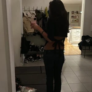 Svart knyt topp från Nelly XS - Säljer en svart croppad topp från Nelly i storlek XS. Toppen har korta ärmar, öppen rygg och knytning bak vilket ger en snygg och trendig look. Perfekt för dig som gillar stilrena och moderna plagg.