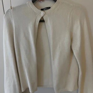 Vit kofta från Gina Tricot XS - Söt vit kofta från Gina Tricot i storlek XS. Koftan har rund halsringning, ribbade kanter och stängs med en knapp upptill. Långärmad och i mjukt stickat material, perfekt att slänga över en topp för en clean look.