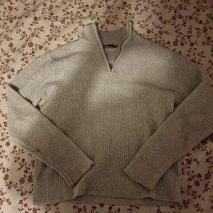 Grå stickad half zip-tröja  - Ribbstickad grå tröja från 15 i storlek S. Tröjan har hög krage med half zip-dragkedja och långa ärmar. Perfekt för lager-på-lager och chill höst- eller vinterstil. Enkel att matcha med jeans och jävligt skönt o stilig har använt 2 gånger / finns inte kvar i lager är jag säker på 