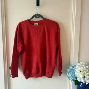 Röd sweatshirt från Off The Wall - En enkel och stilren röd sweatshirt från Off The Wall. Tröjan har rund halsringning, ribbade muddar vid ärmslut och nederkant samt är tillverkad i en mjuk blandning av polyester och bomull. Perfekt för dig som gillar en klassisk look.