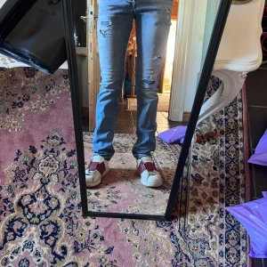 Ljusblå slitna slim jeans från Jack and Jones 30/34  - Säljer ett par ljusblå jeans med slitningar och hål på låren. Jeansen har rak passform och klassisk femficksdesign. Perfekta för dig som gillar en avslappnad och trendig look. Materialet är jeans och färgen är ljusblå. Modellen är 178cm 70kg midja 38cm längd 103cm (16)