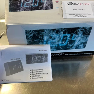 Modern digital klocka med marmormönster - Modern digital klocka med marmormönster, tydlig LED-display och flera språk i manualen. Produkten är ny i förpackning, men kartongen har synliga skador och slitage. Perfekt som stilren inredningsdetalj eller väckarklocka. Enkel att använda och passar i alla rum.