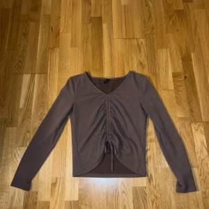 Brun ribbad topp med snörning Vero Moda - Säljer en brun långärmad topp från Vero Moda med ribbad struktur och v-ringning. Toppen har snygg snörning framtill som ger en rynkad effekt och croppad passform. Perfekt för dig som gillar trendiga detaljer och vill ha en bekväm men stilren look. Stl L, pris 100 kr, har denna i svart också (säljs också).💓💓 använd fåtal gånger 