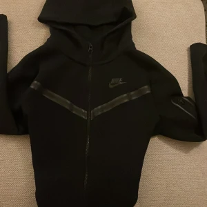 Nike tröja (147-158) - Säljer nu en väldigt snygg Nike tech tröja, tröjan är aldrig använd bara legat i garderoben då den var för liten. Pris kan diskuteras. Varför jag inte kategoriserar den i ”ny skick” är för att den inte har kvar etikett. Snygg sportig tröja som är lätt att matcha med.