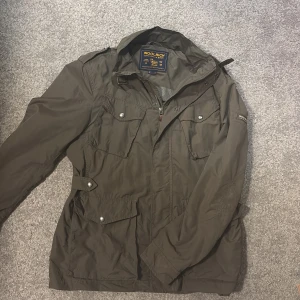 Olivgrön vindjacka från Woolrich - Säljer en olivgrön vindjacka från Woolrich, i ett mycket fint skick. Perfekt nu till hösten för en stilig look. Skriv för frågor