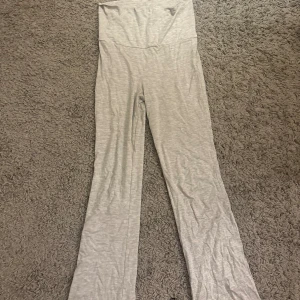 Ljusgrå mjukisbyxor från Gina Tricot - Superbekväma ljusgrå mjukisbyxor från Gina Tricot i stretchigt och mjukt bomullsmaterial. Byxorna har hög midja och raka ben, perfekta för en chill och avslappnad stil. Passar dig som gillar enkel och clean look.