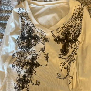 Vit ribbad långärmad tröja med kors - Vit tröja med kors på framsidan men en liten fläck på baksidan av armen annars aldrig använt!