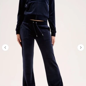 Mörkblå mjukisbyxor med snörning - Mysiga mörkblå mjukisbyxor i velour med bred resår i midjan och snörning framtill. Byxorna har raka ben och stora fickor framtill, perfekta för en chill och avslappnad stil.