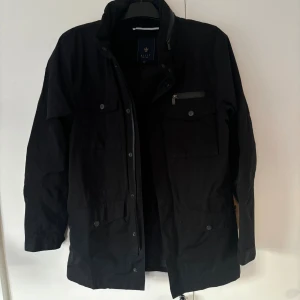 Riley fieldjacket - Svart snygg elegant Riley jacka i använt men bra skick och storlek 48 (S/M) säljes. Perfekt nu till vintern för att hålla dig varm och go samtidigt som stilmedveten. Tveka inte vid minsta fråga eller fundering!