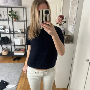 Mörkblå stickad topp Gina Tricot - Säljer en mörkblå stickad topp från Gina Tricot med korta ärmar och rund hals. Modellen är croppad och har en mjuk, fluffig känsla. Perfekt att styla med ljusa jeans eller kjol för en chill look. Passar bra på en XS-S