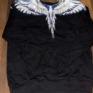 Svart Marcelo Burlon  - Svart långärmad tröja från Marcelo Burlon. Vingtryck i vitt och blått. Skriv privat för fler frågor. KVITTO FINNS INTE.