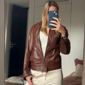 Brun skinnjacka från Filippa K - Snygg brun skinnjacka från Filippa K med klassisk krage, dragkedja framtill och coola detaljer. Finns en defekt men den är på insidan så syns inte. 